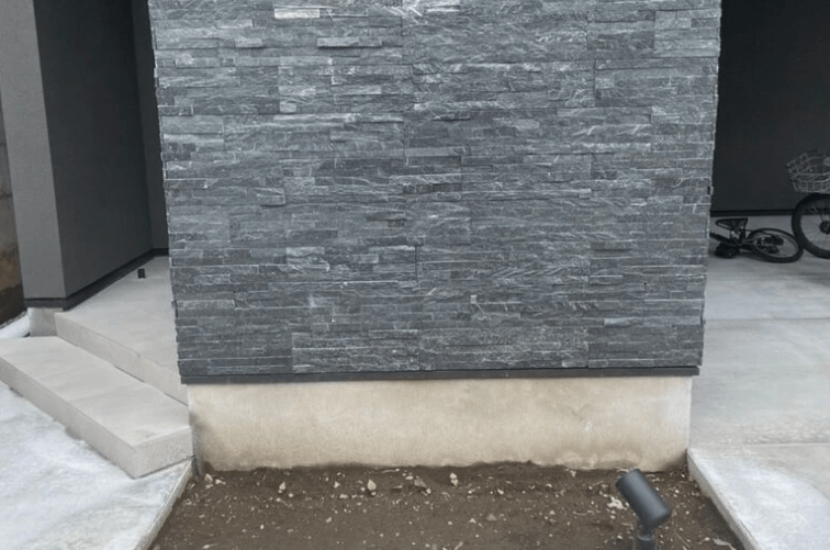 暗い玄関前と主庭が激変!アオダモとハイノキでつくるお洒落な庭の実例 グレーの石材風の壁